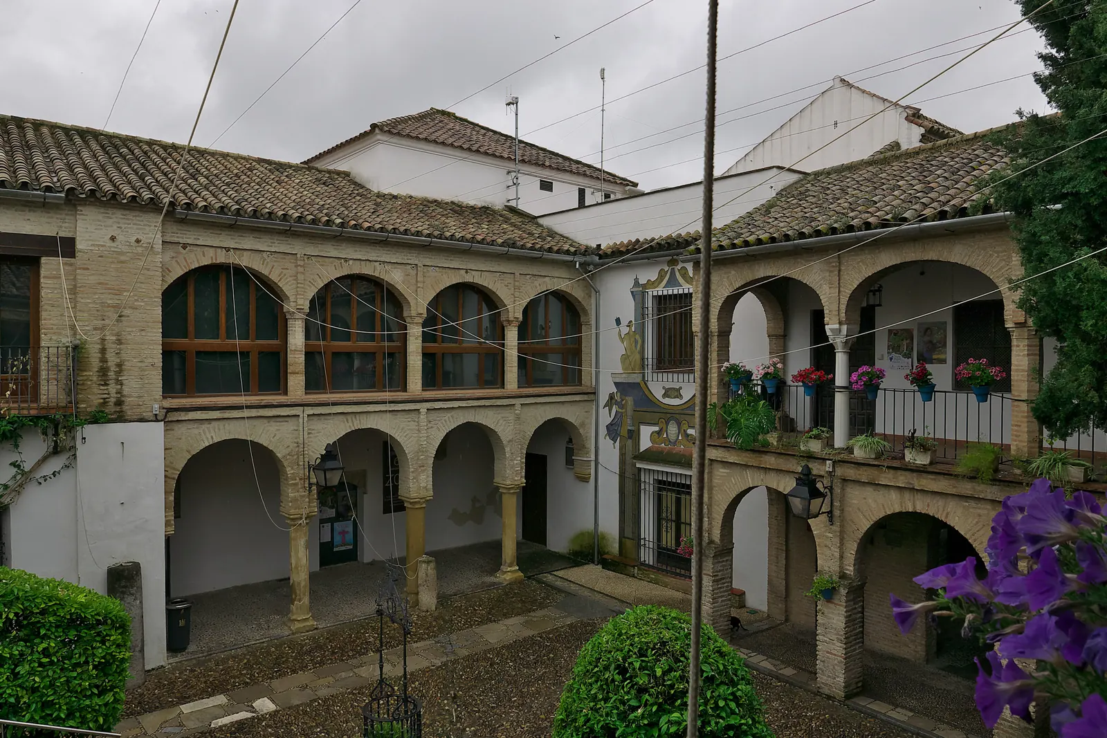 The arched two-storey Patio del Zoco in Córdoba's old centre, seen from above, with tiled roofs and flowers